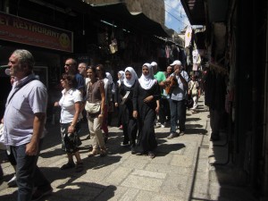 Muslim women and Christian pilgrims walk in the quarter.