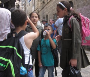 A group of Muslim children stop for refreshment. 