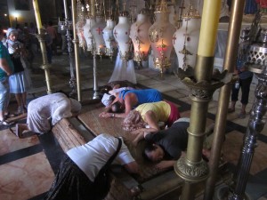 Pilgrims reverence a rock slab connected with the burial of Jesus.