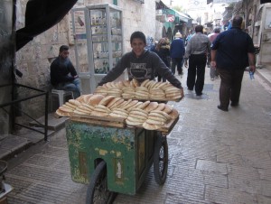 A boy delivers bread in the old city.